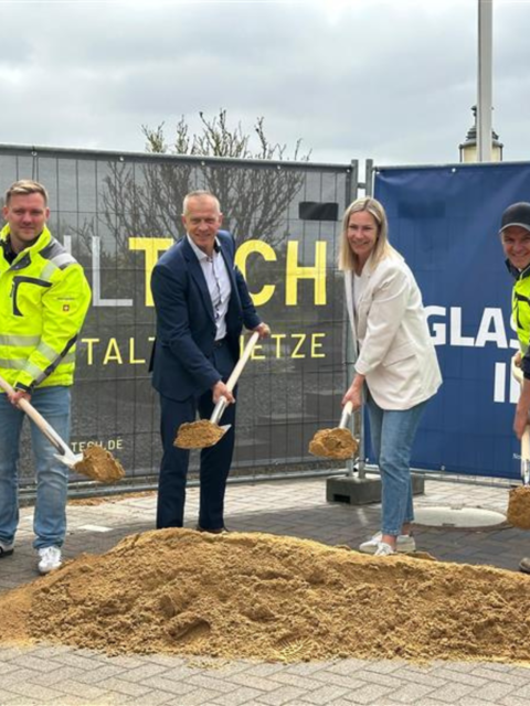Projektbeteiligte mit Spaten in der Hand vor einem Sandhaufen