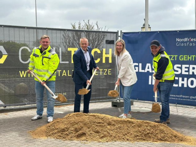 Projektbeteiligte mit Spaten in der Hand vor einem Sandhaufen